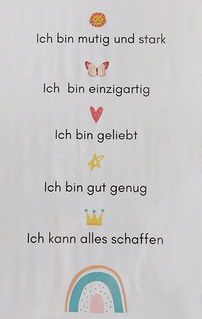 Abgebildet ist ein Plakat mit positiven Sätzen zur Stärkung und bunten Symbolen, wie z.B. „Ich bin mutig und stark“ oder „Ich bin gut genug“.